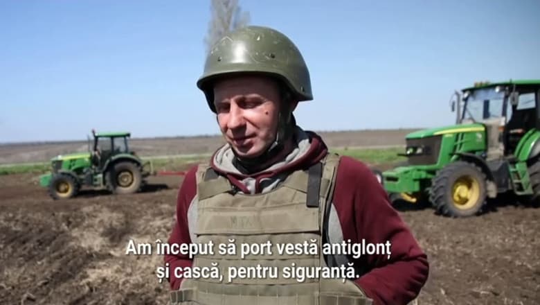 Muncesc în câmp cu vestă antiglonț și cască